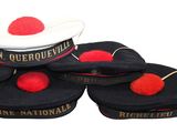 several black hats with red pom poms are stacked on top of each other