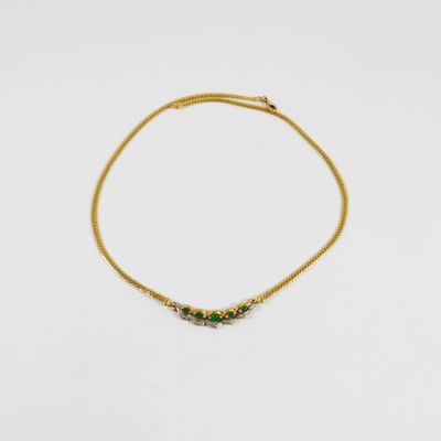 un bracelet en or orné d'émeraudes sur fond blanc