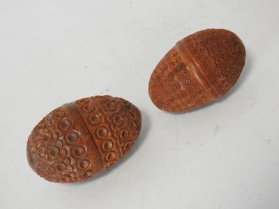 pair of carved wooden buttons on a white surface