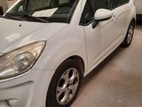 the small white car is parked in the garage next to other cars