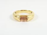 a close up of a gold ring with a pink stone