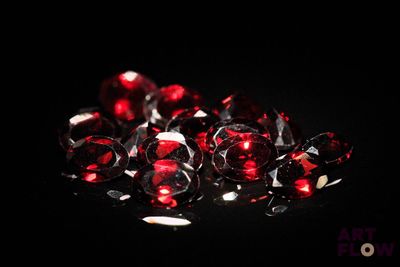 a close up of a bunch of red diamonds on a black surface