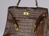 brown alligator skin handbag with gold hardware and handles