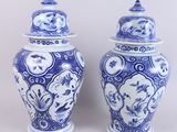 pair of blue and white vases with lids on a white background