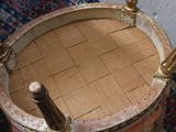 a wooden drum sitting on a rug on the floor