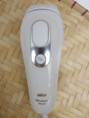 a white electric shaver sitting on top of a wooden floor