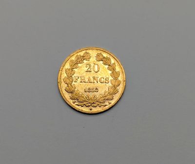 un gros plan d'une pièce de monnaie posée sur une table, sur fond gris
