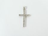 un gros plan d'une croix sur une surface blanche, ornée de diamants