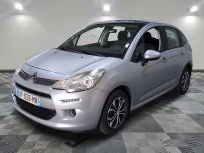 la petite voiture argentée est garée sur un sol en damier