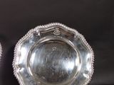 pair of silver plated dishes with beaded rims on a black background