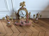 a clock that is sitting on the floor next to other items