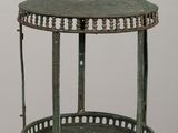 a green metal lantern on a table with a white wall