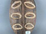 une image représentant un masque en bois sur fond gris