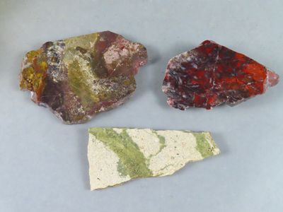 trois pierres de couleurs et de formes différentes posées sur une table
