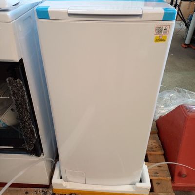 a white dishwasher sitting on a pallet next to an oven