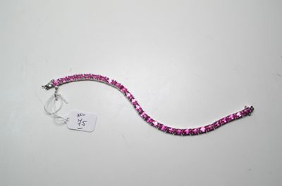 bracelet composé de perles roses et d'une étiquette blanche sur un fond blanc
