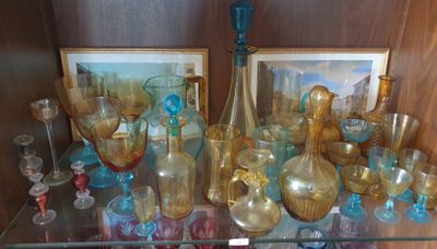 une étagère en verre sur laquelle sont posés de nombreux objets en verre
