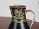 a black and gold pitcher sitting on a wooden table