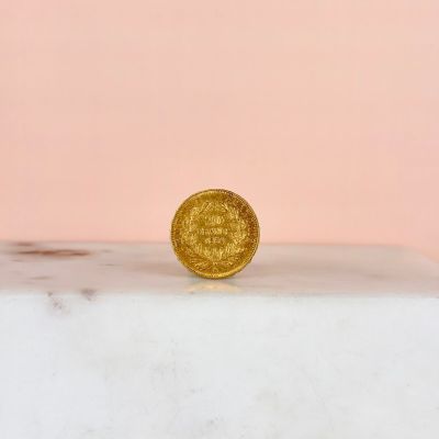a gold coin sitting on top of a marble slab