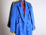 a blue coat hanging on a hanger in a room