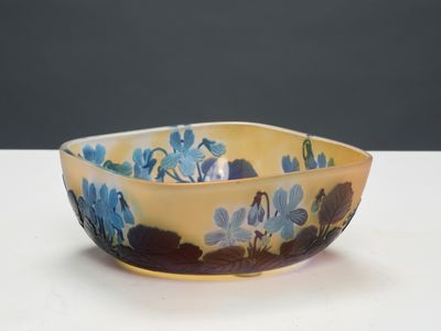 un bol jaune orné de fleurs bleues, posé sur une table