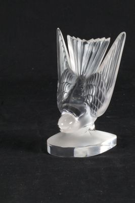 une sculpture en verre représentant un poisson, posée sur un socle