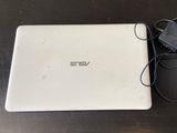 un ordinateur portable blanc posé sur une table à côté d'une souris
