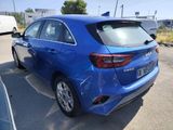 the rear end of a blue car parked in a parking lot