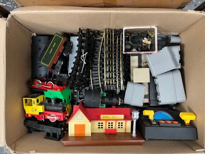 a cardboard box filled with toy trains and other toys