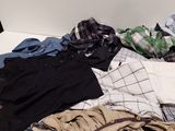 a pile of clothes sitting on the floor next to a chair