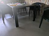 une table et des chaises dans une pièce avec un mur en briques en arrière-plan