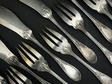 beaucoup de cuillères et de fourchettes sur une table noire