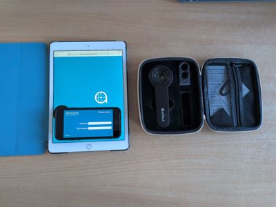 une tablette et un portefeuille posés sur une table à côté d'un téléphone portable