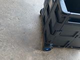 une caisse noire posée par terre à côté d'un objet bleu