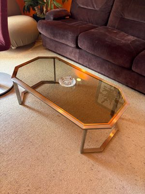 a coffee table with a glass top in the middle of a living room