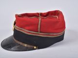 a red and black hat on a white surface