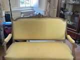 a yellow couch in a living room with a rug on the floor