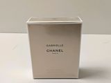 un flacon de parfum Chanel dans un coffret blanc posé sur une table