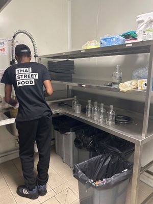 un homme qui se tient debout dans la cuisine en train de préparer à manger