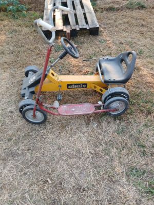 a small yellow tricycle that is sitting in the grass