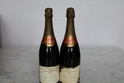 two bottles of wine sitting on top of a table next to each other