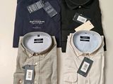 trois chemises pour homme, encore étiquetées, posées sur une table