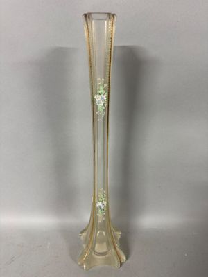 a tall glass vase with a green flower in the middle