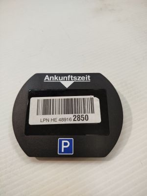 un bouton noir sur lequel figure un code-barres, posé sur une table