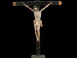 statue of a crucifix with a wooden cross on a black background
