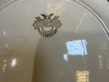 a white plate that has a gold emblem on it