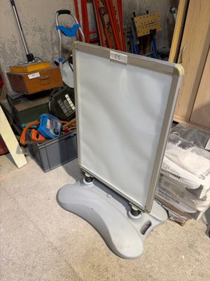 a white board sitting on a stand in a room