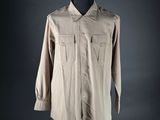 the shirt is tan and has buttons on the chest