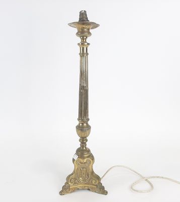 une lampe de table en laiton ancien sur fond blanc, avec un cordon