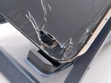a broken cell phone sitting on top of a stand